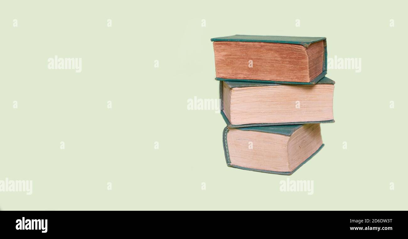Two old books lie on a plain green background Stock Photo