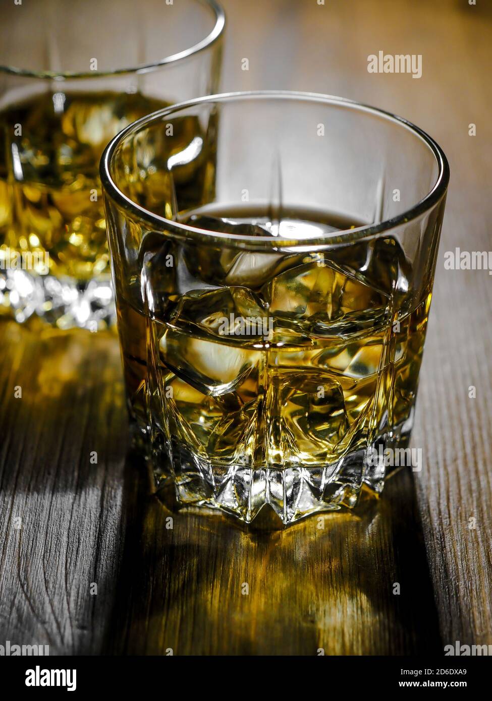 Two glasses of whisky on the rocks on a wooden table Stock Photo - Alamy