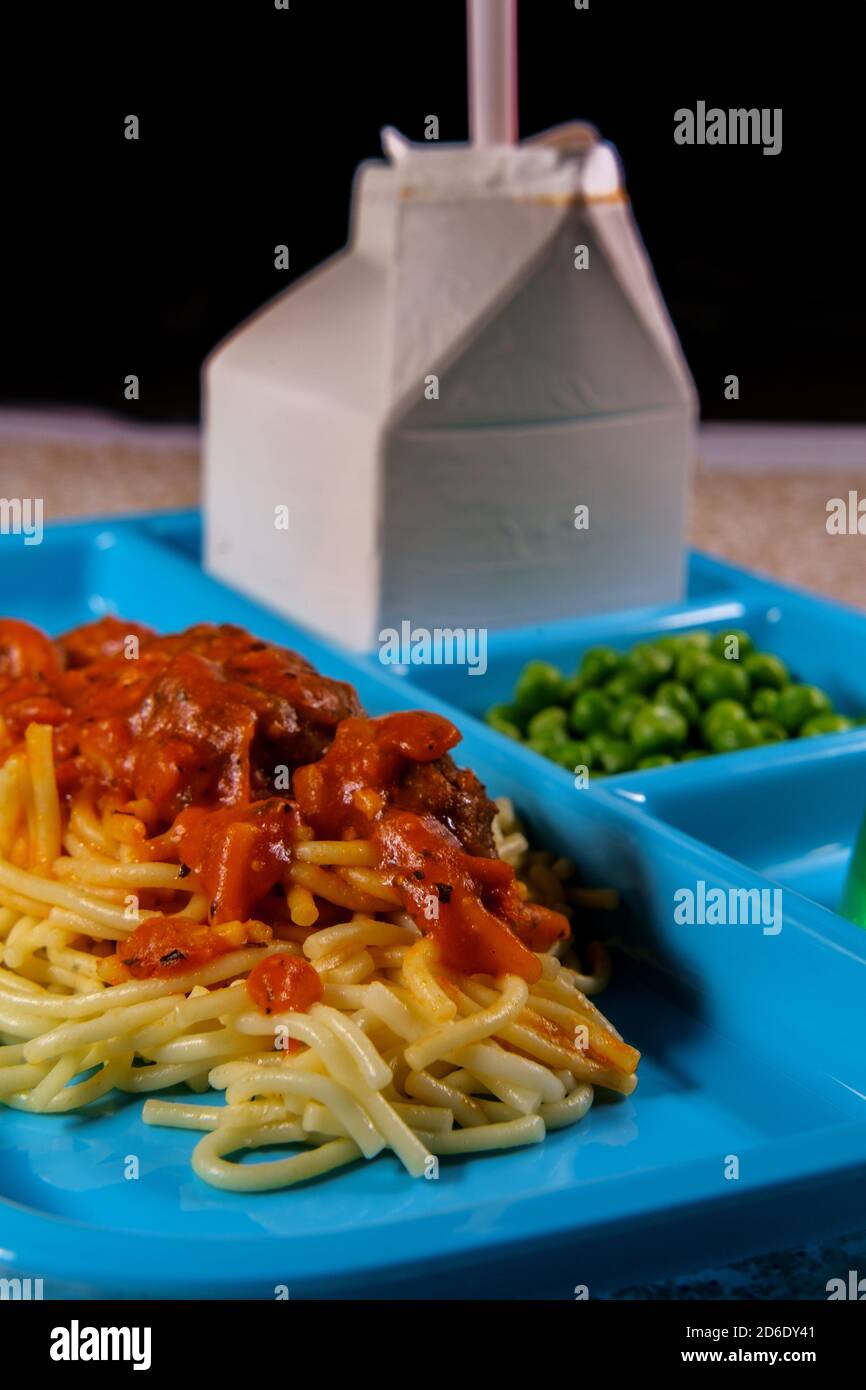 Grade school lunch tray of Italian spaghetti and meatballs with green