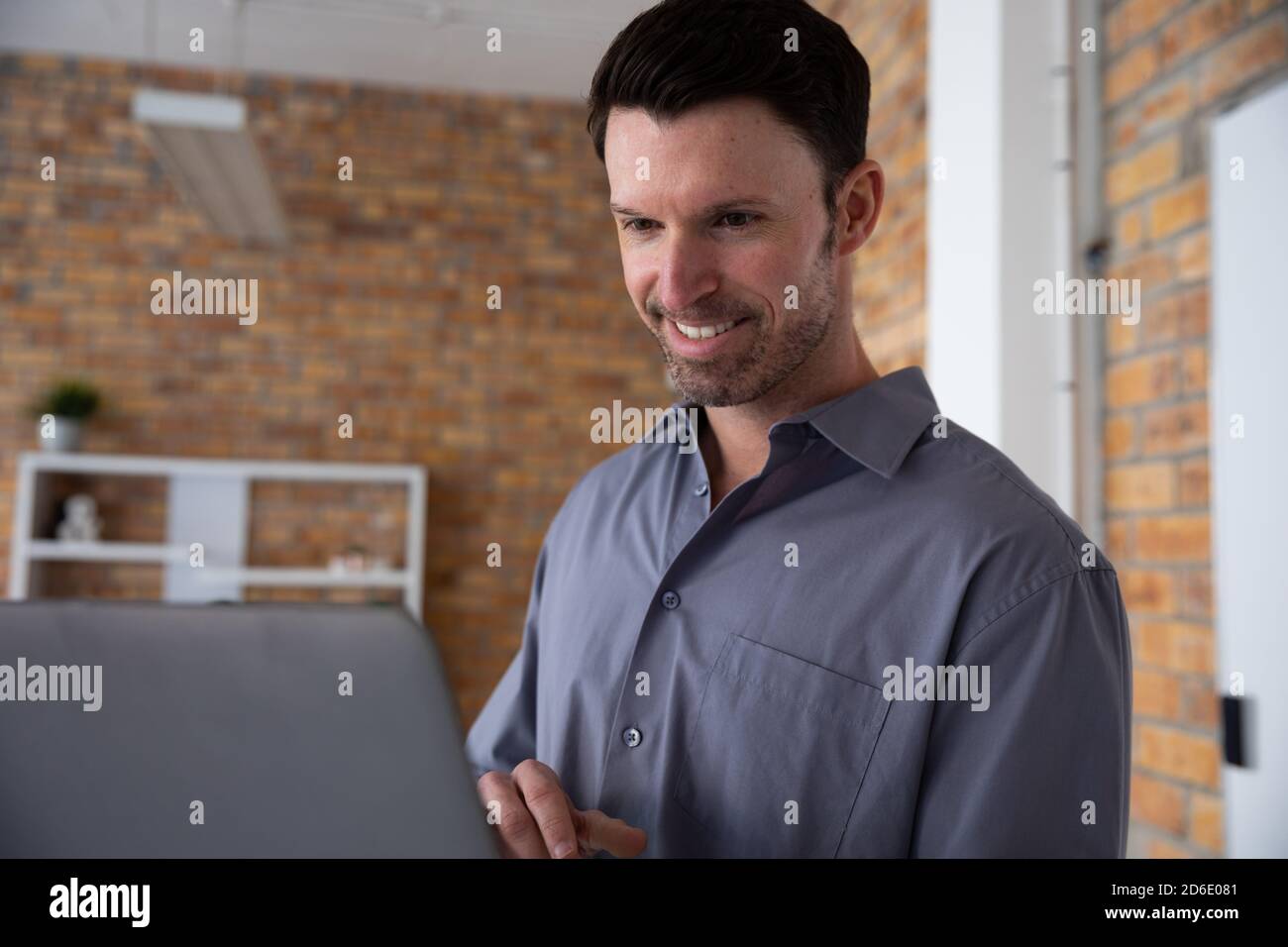 Man smiling while using laptop Stock Photo