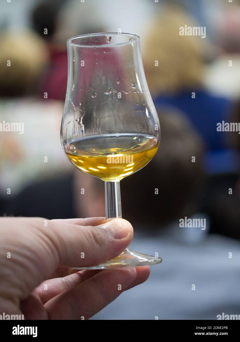 Hand holding a snifter glass filled with whisky, whisky tasting event Stock Photo Alamy