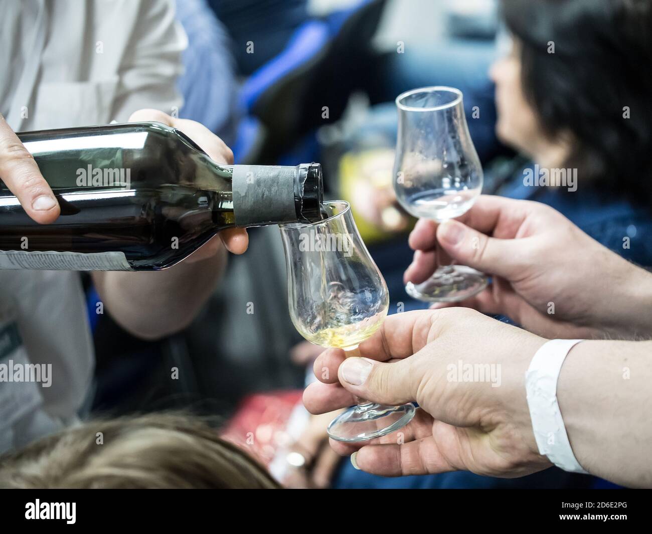 Hands holding a snifter glass filled with whisky, whisky tasting event ...