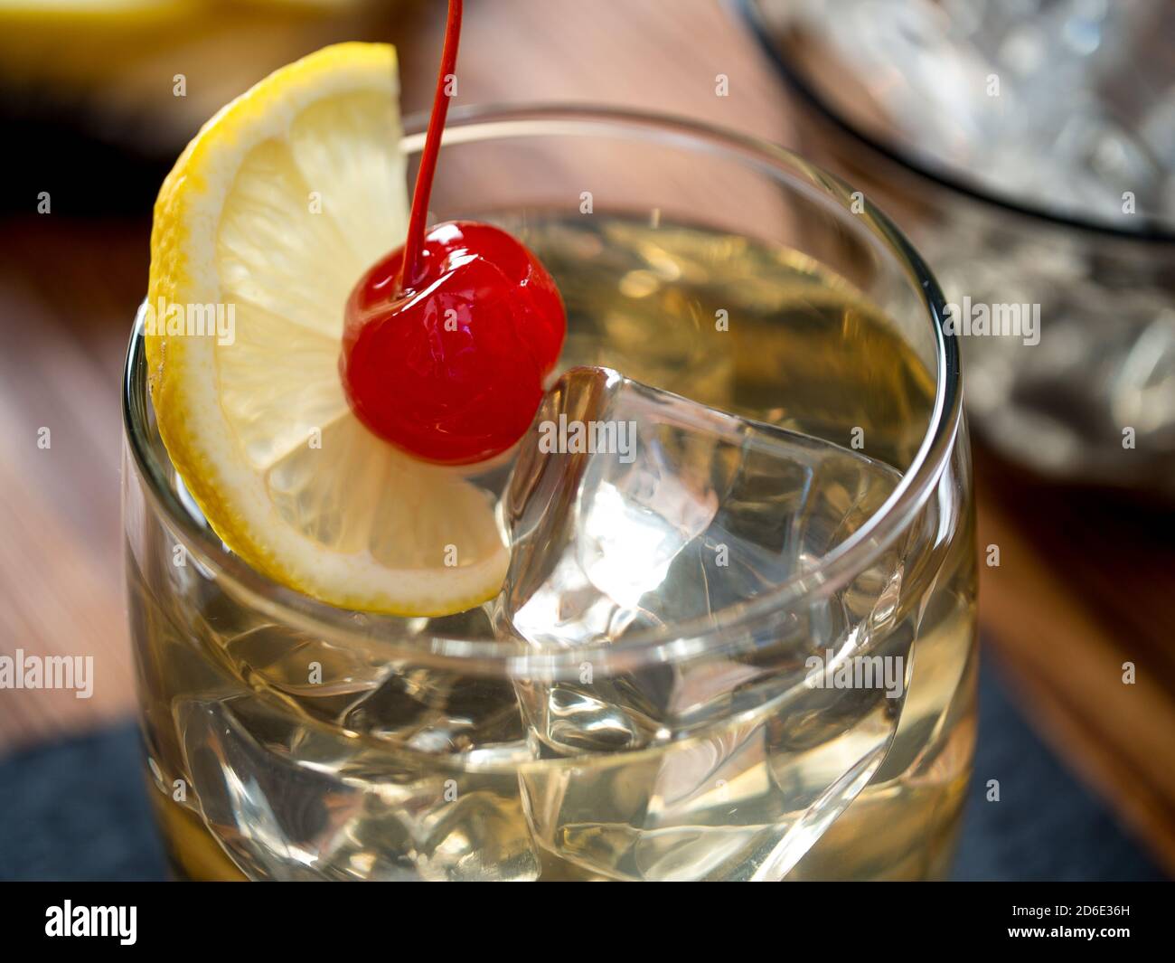 Whiskey sour cocktail garnished with lemon slice and maraschino cherry