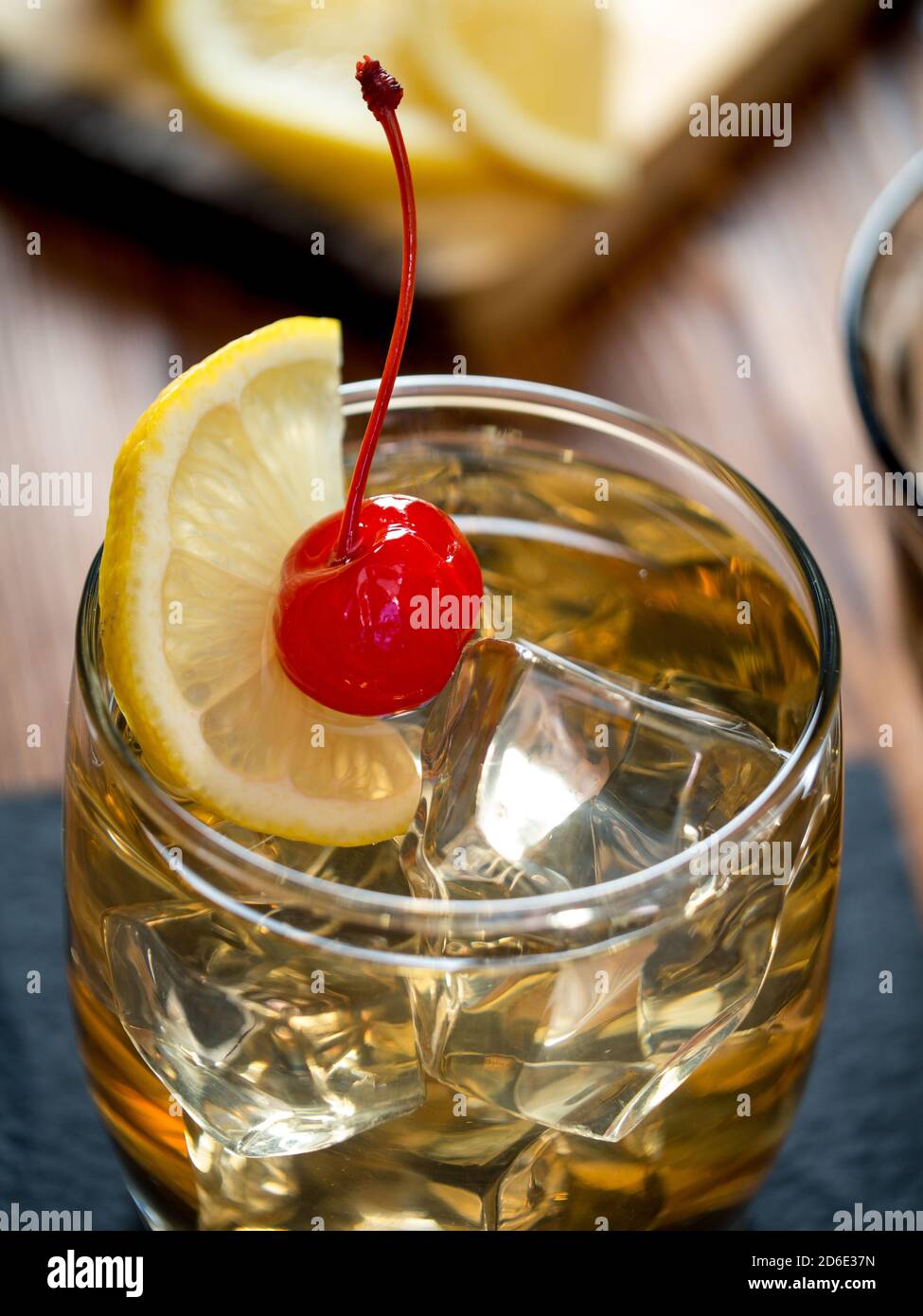 Whiskey sour cocktail garnished with lemon slice and maraschino cherry