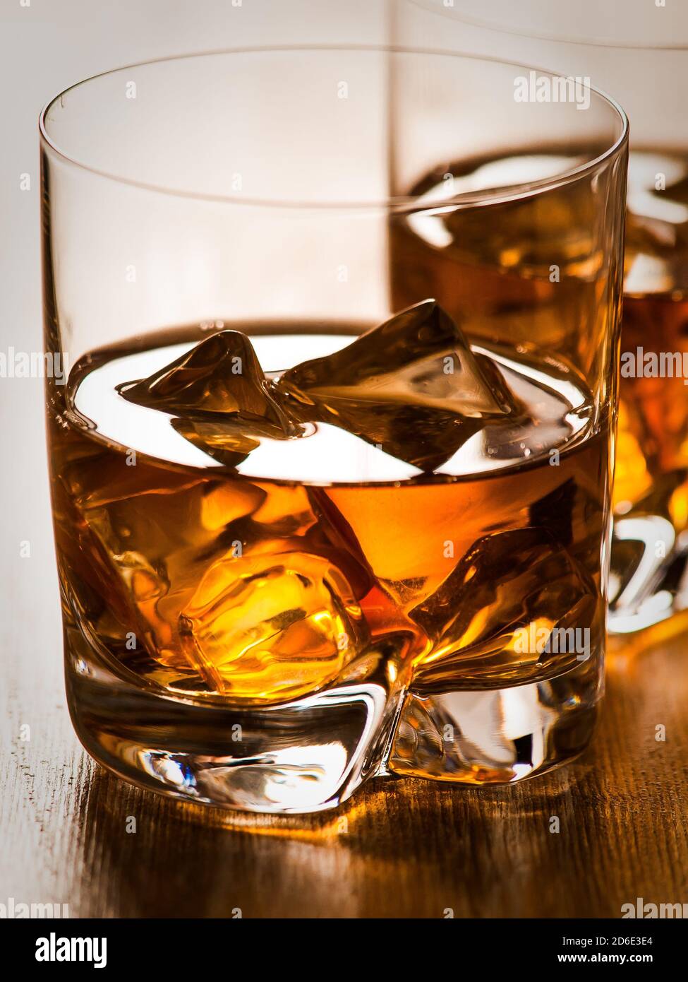 Two glasses of whisky on the rocks on a wooden table Stock Photo - Alamy