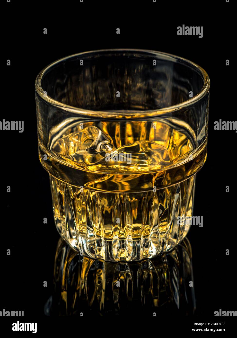 Glass of whiskey on the rocks on black background Stock Photo - Alamy