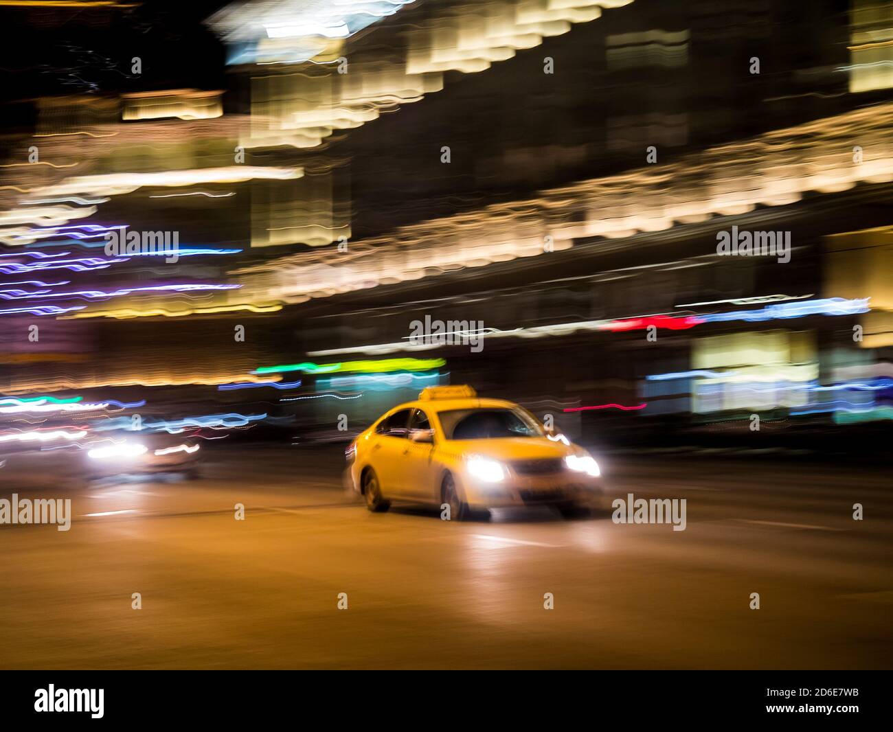 Yellow taxi cab on a city street at night, intentional motion blur ...