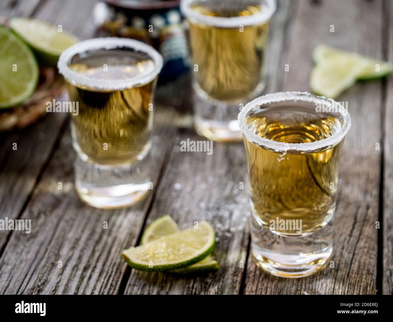 Tequila shots served with salt rim and lime wedges on a grunge wooden table  Stock Photo - Alamy, image size:1300x1065