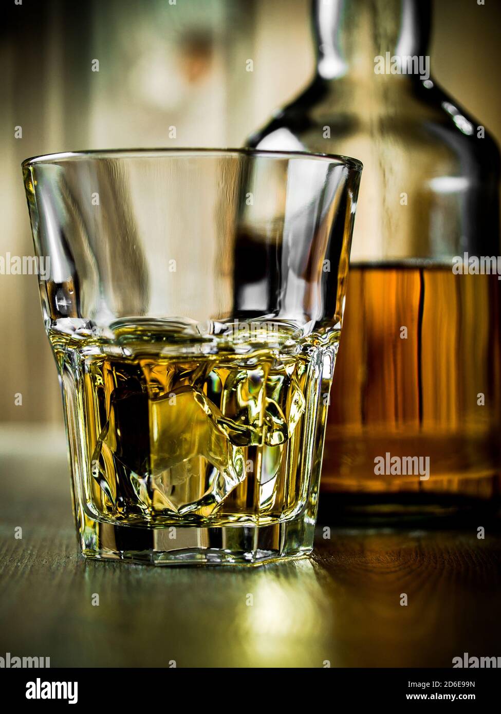 Glass of whiskey on the rocks and a bottle on a wooden background Stock ...