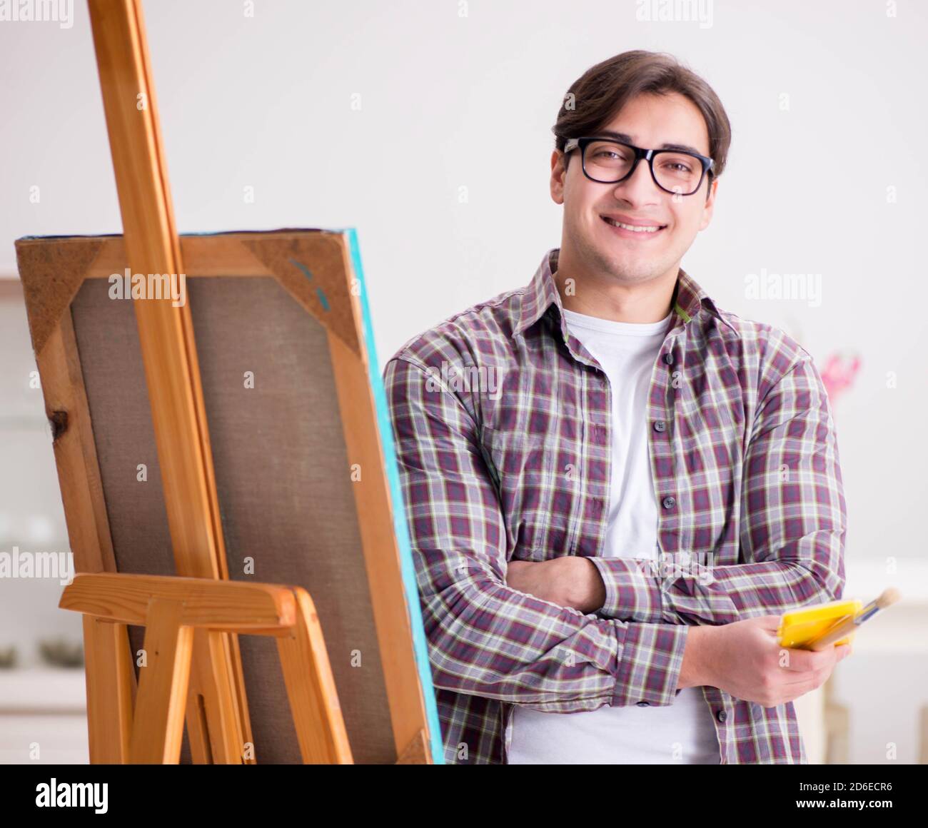 The young male artist drawing pictures in bright studio Stock Photo - Alamy