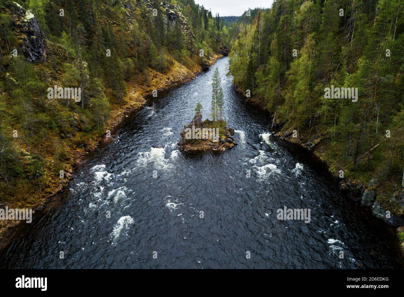 Small rocky island in the middle of river rapids in the taiga forest canyon in Finnish nature, Northern Europe. Stock Photo