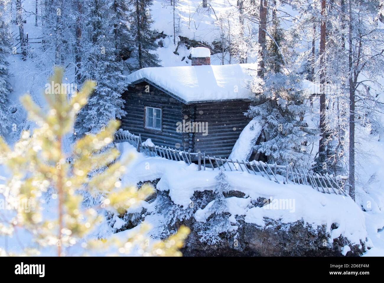 A small cozy wintery cabin by the river in Finnish taiga forest, Northern Europe. Stock Photo