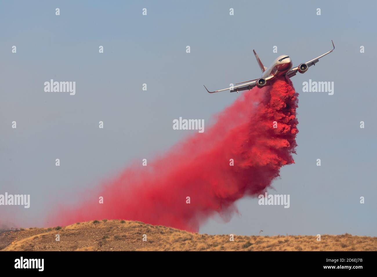 A CAL Fire retardant dropping airplane makes a drop along the ridge of a hillside off of Agua Dulce Canyon Rd. in Los Angeles during the Soledad Fire Stock Photo