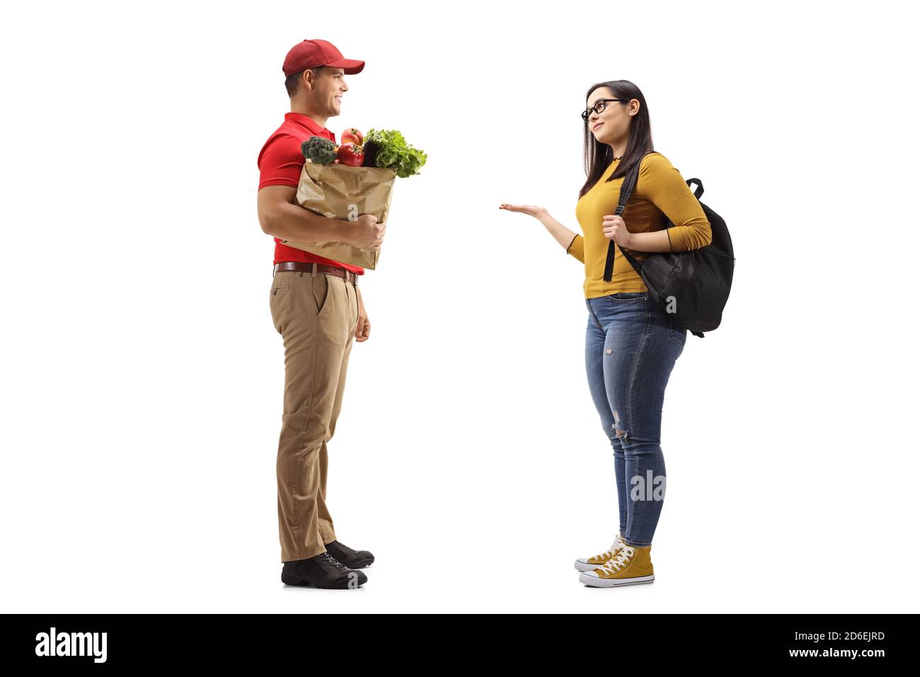 Full length profile shot of a man delivering a bag of groceries to a female student isolated on white background Stock Photo