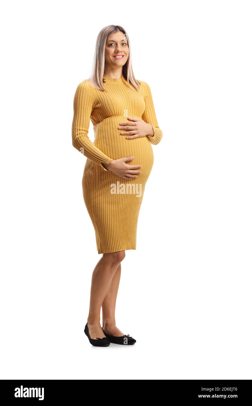 Full length portrait of a pregnant woman in a yellow dress holding her belly and smiling isolated on white background Stock Photo