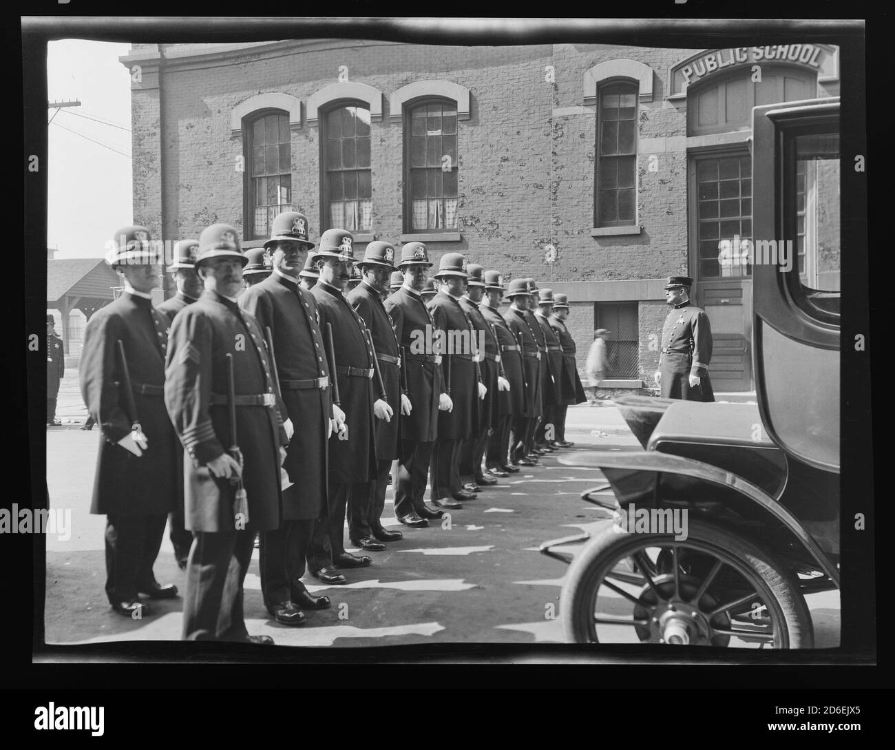 Inspection of uniformed Chicago police officers standing in front of an unidentified public school, Chicago, Illinois, 1911. Stock Photo