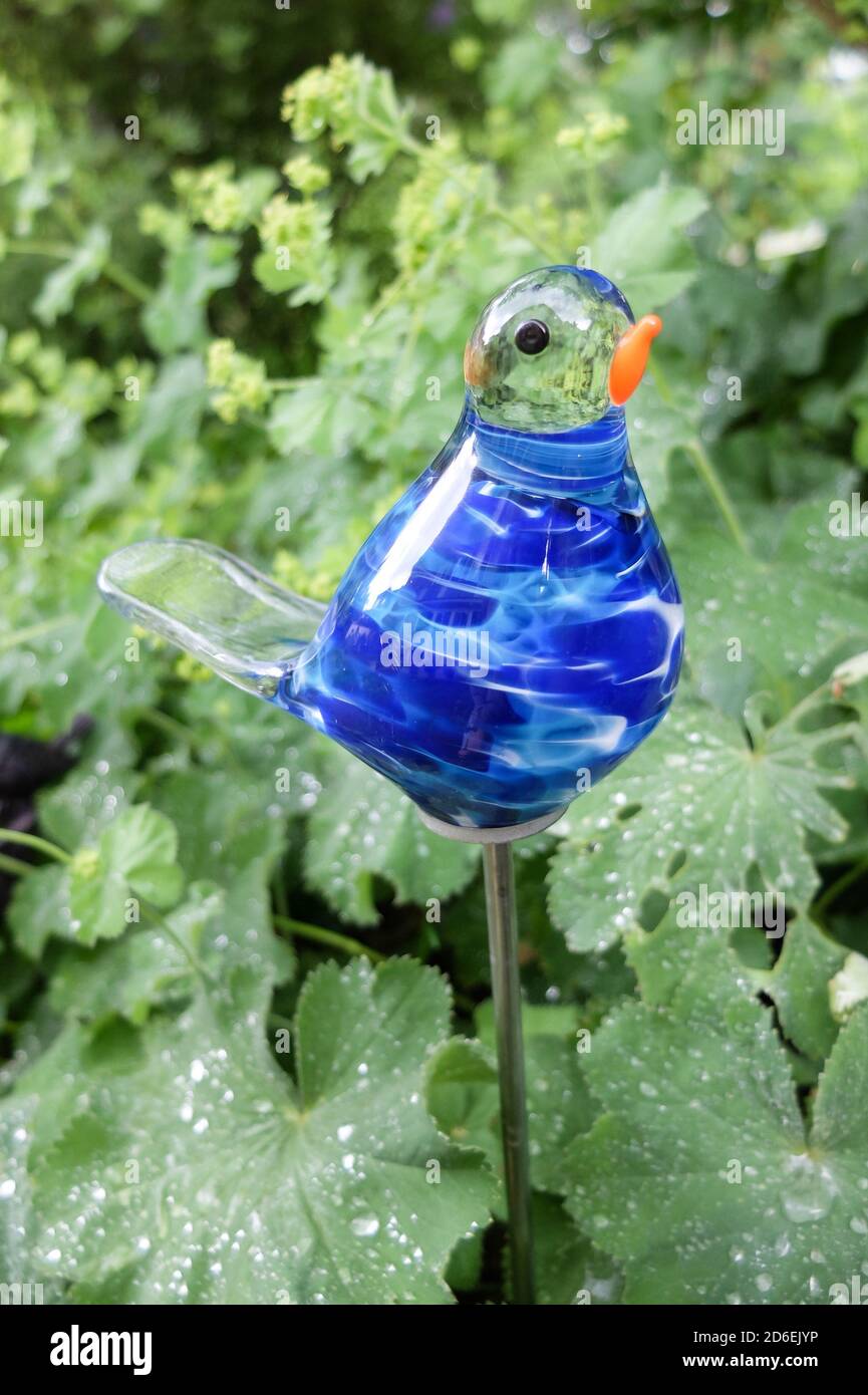 Garden decoration made of glass, blue bird as a garden plug Stock Photo