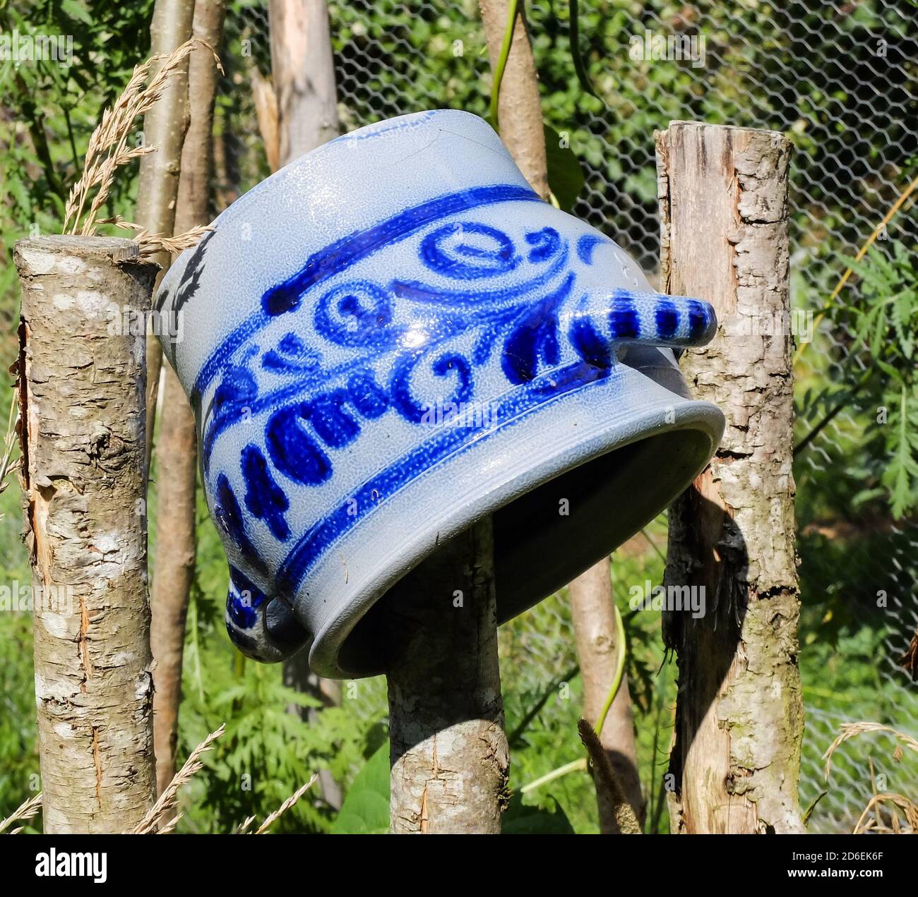 Old earthenware pot on the fence as a garden decoration Stock Photo