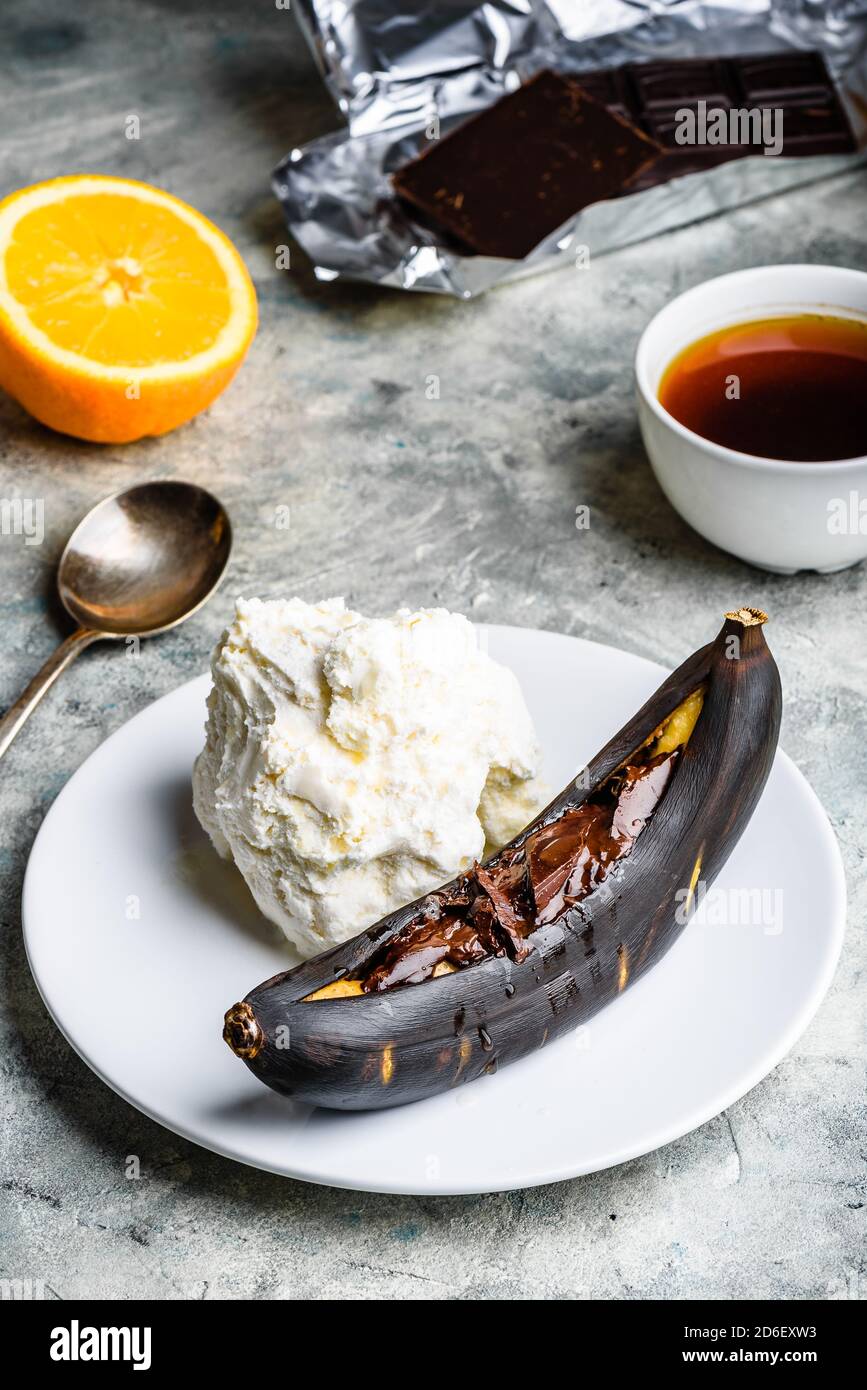 Grilled banana with dark chocolate and vanilla ice cream Stock Photo