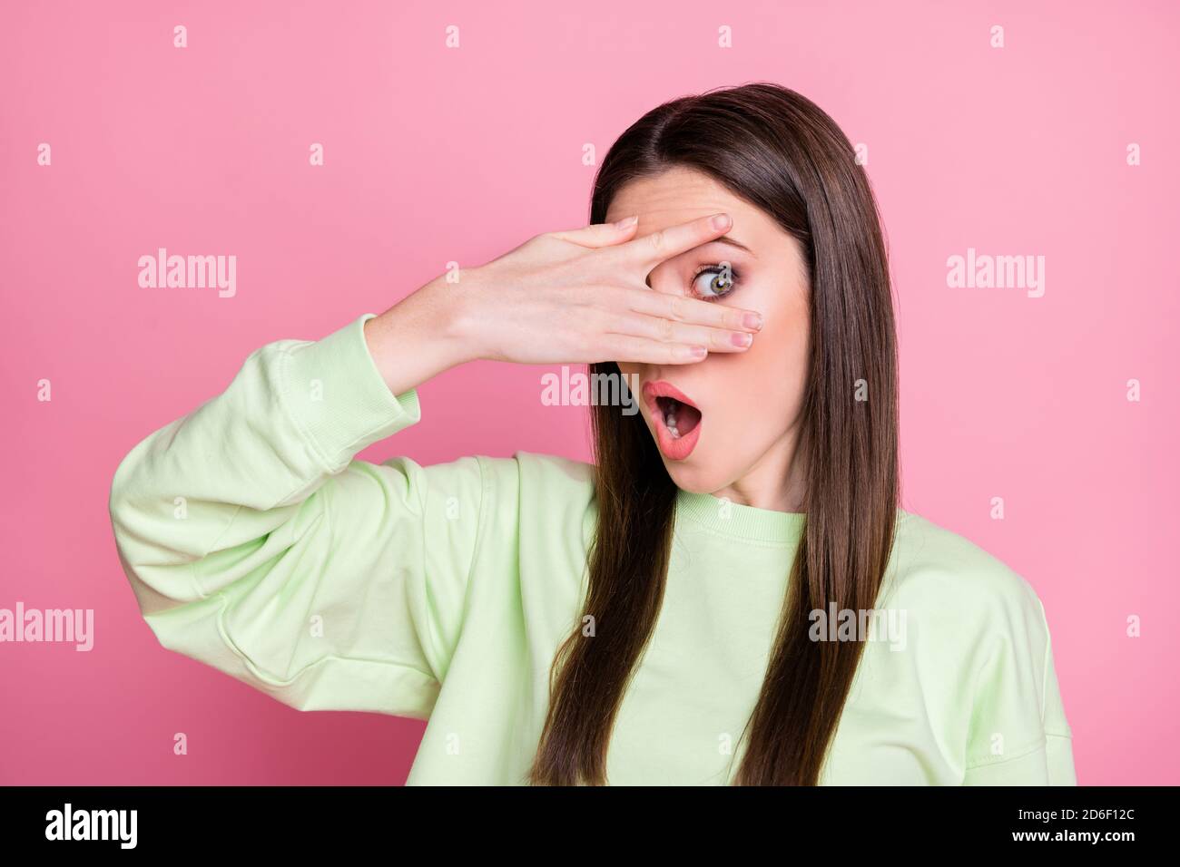 Closeup photo of attractive funny lady closing eyes arms peeking glance wanna know secret curious person wear casual green sweatshirt pullover Stock Photo
