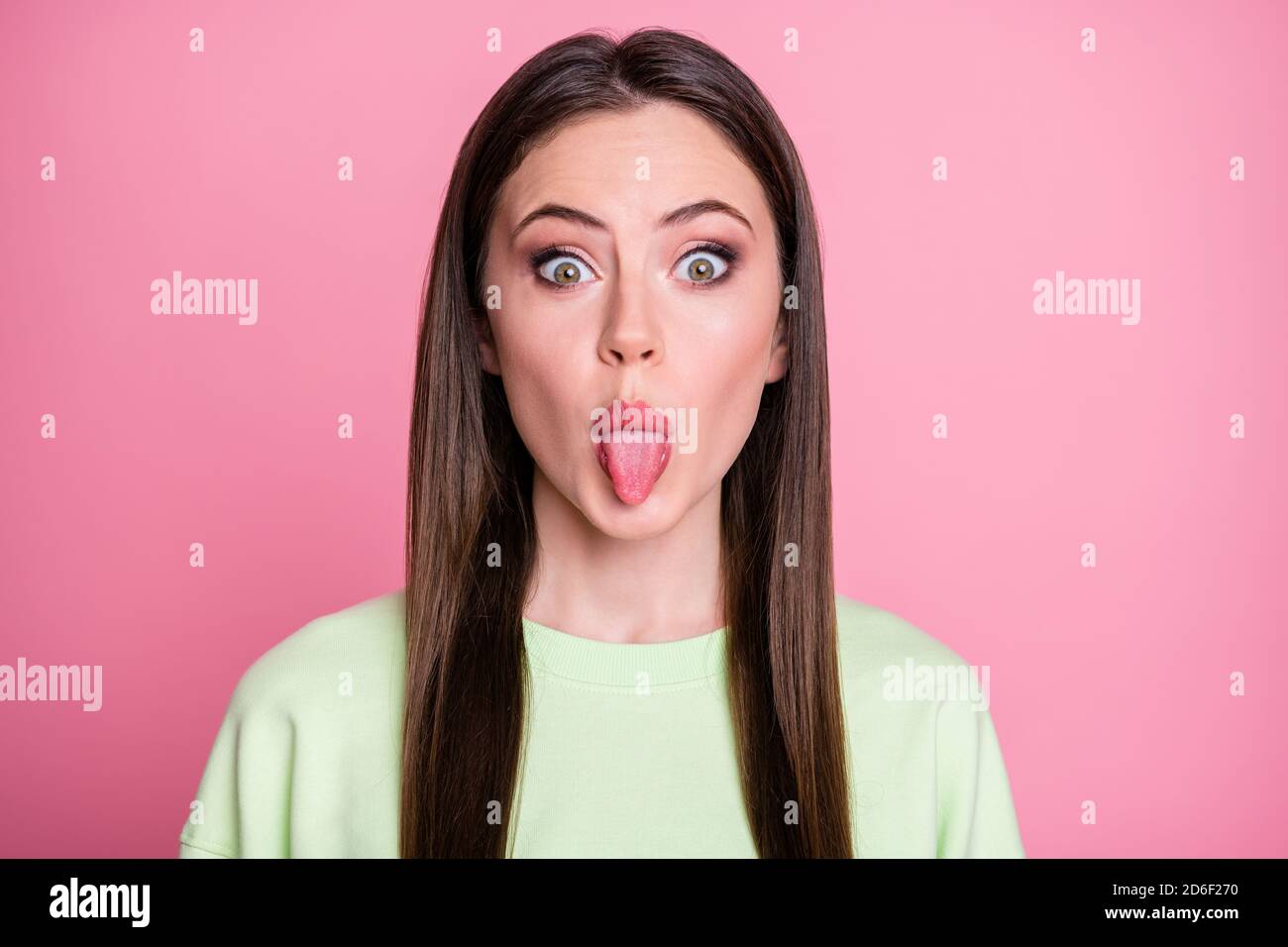 Closeup photo of funny crazy lady straight long hairdo funny girlish sticking tongue out mouth playful foolish mood wear casual green sweatshirt Stock Photo Alamy