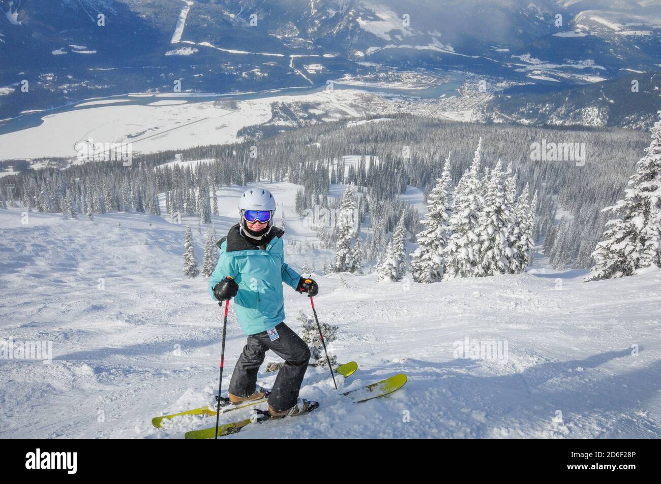 A mature woman skiing the powder on a sunny, cold day in Revelstoke British Columbia. Model release. Stock Photo
