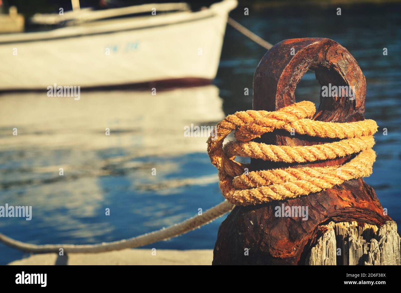 Rusty old boat cleat and old rope fastened to it Stock Photo - Alamy