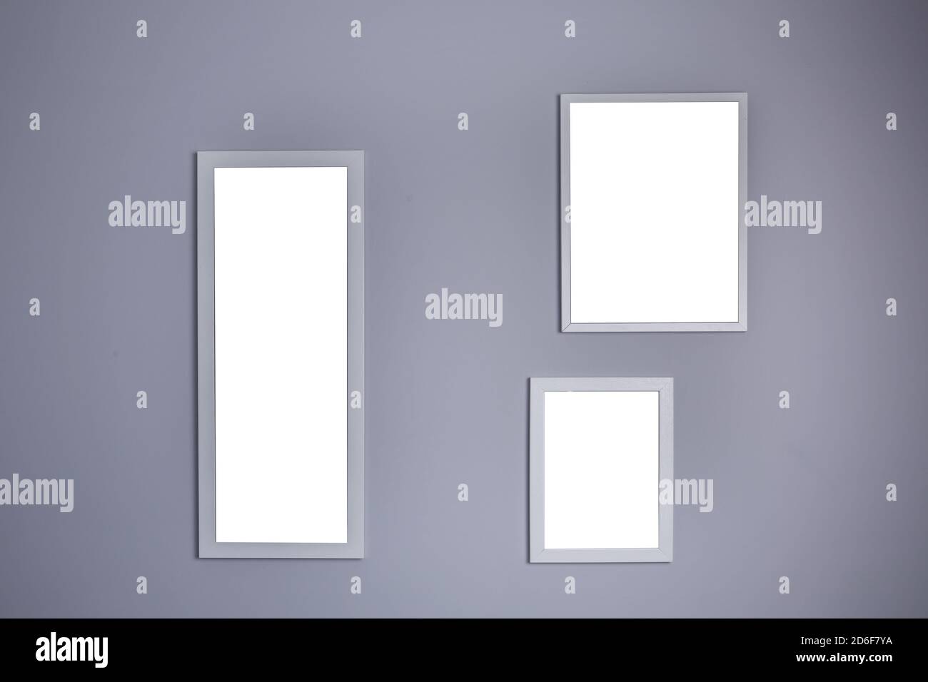 Poster mockup with three frames on empty grey wall  Stock Photo