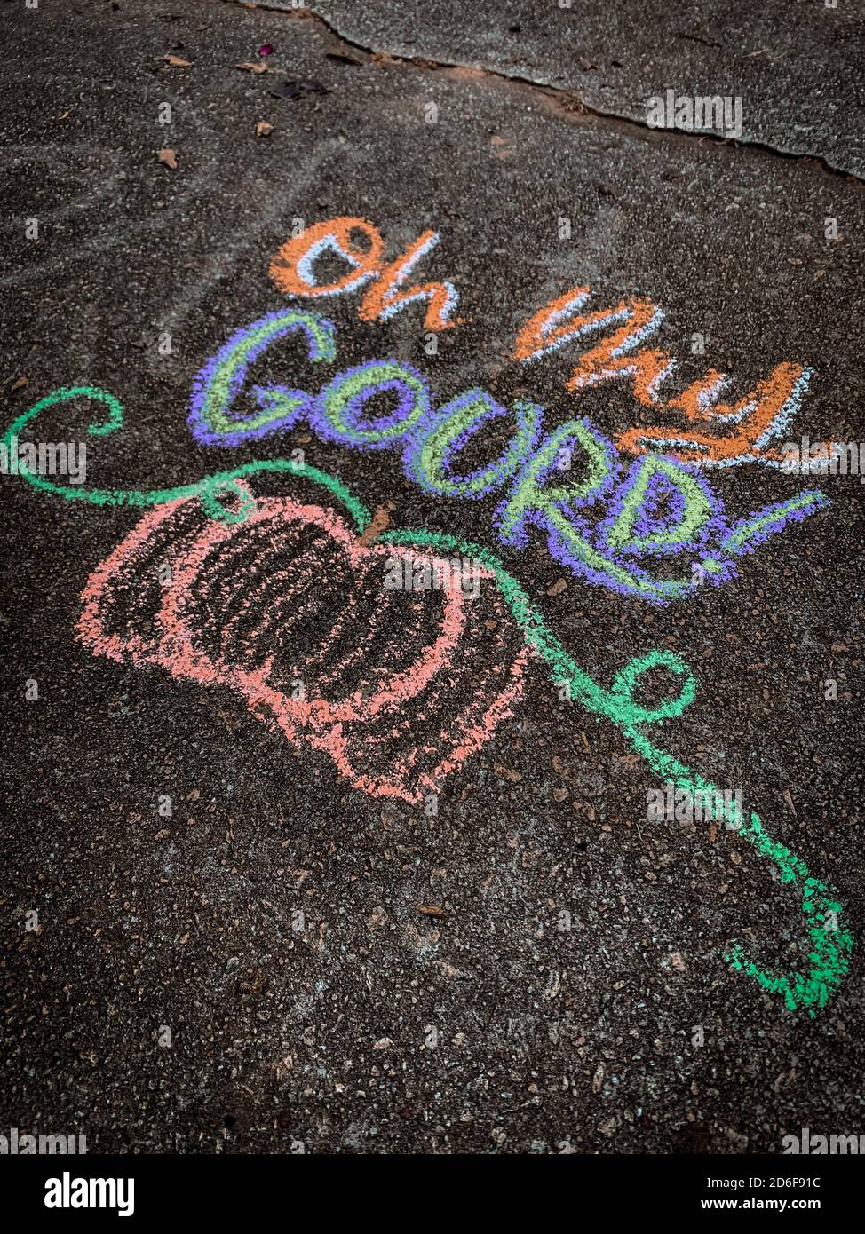 Colorful fall-themed chalk art on a driveway that says, "Oh my gourd!" with  a pumpkin underneath Stock Photo - Alamy