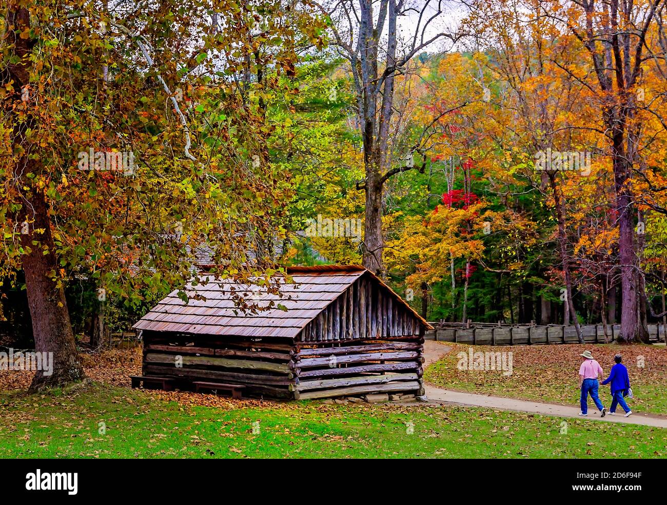 A couple walks down the path toward the blacksmith shop at the John P. Cable Mill Complex in Great Smoky Mountains National Park in Tennessee. Stock Photo