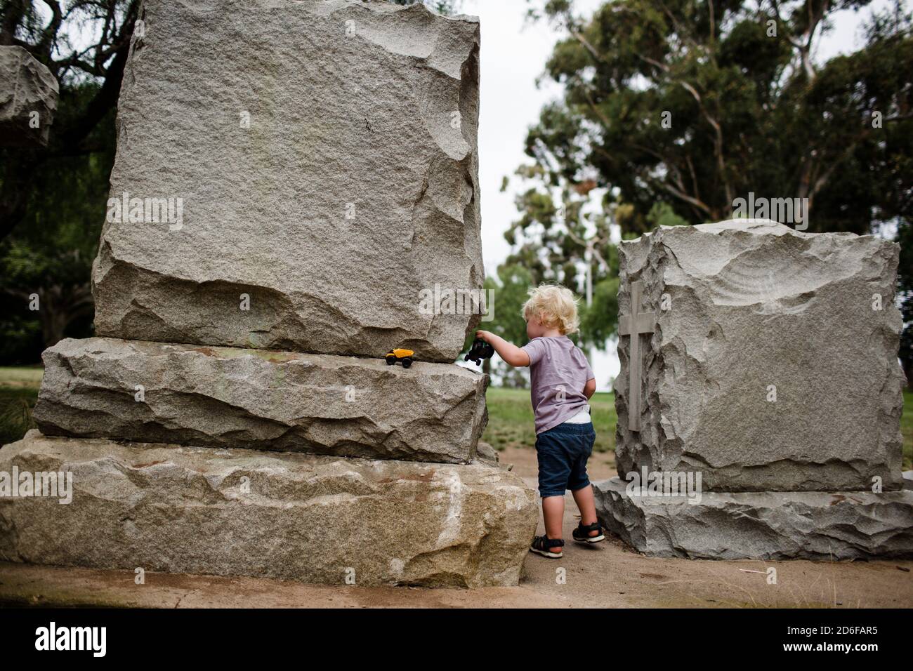 Two Year Old Standing Between Headstones at Park Stock Photo - Alamy