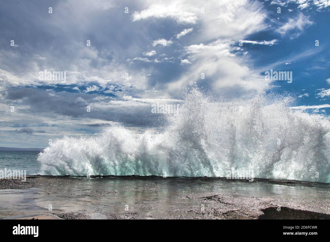 Dramatic dfisplay od the explosiveness of nature seen by a huge wave breaking against the pier at Olawalu Landing on Maui. Stock Photo
