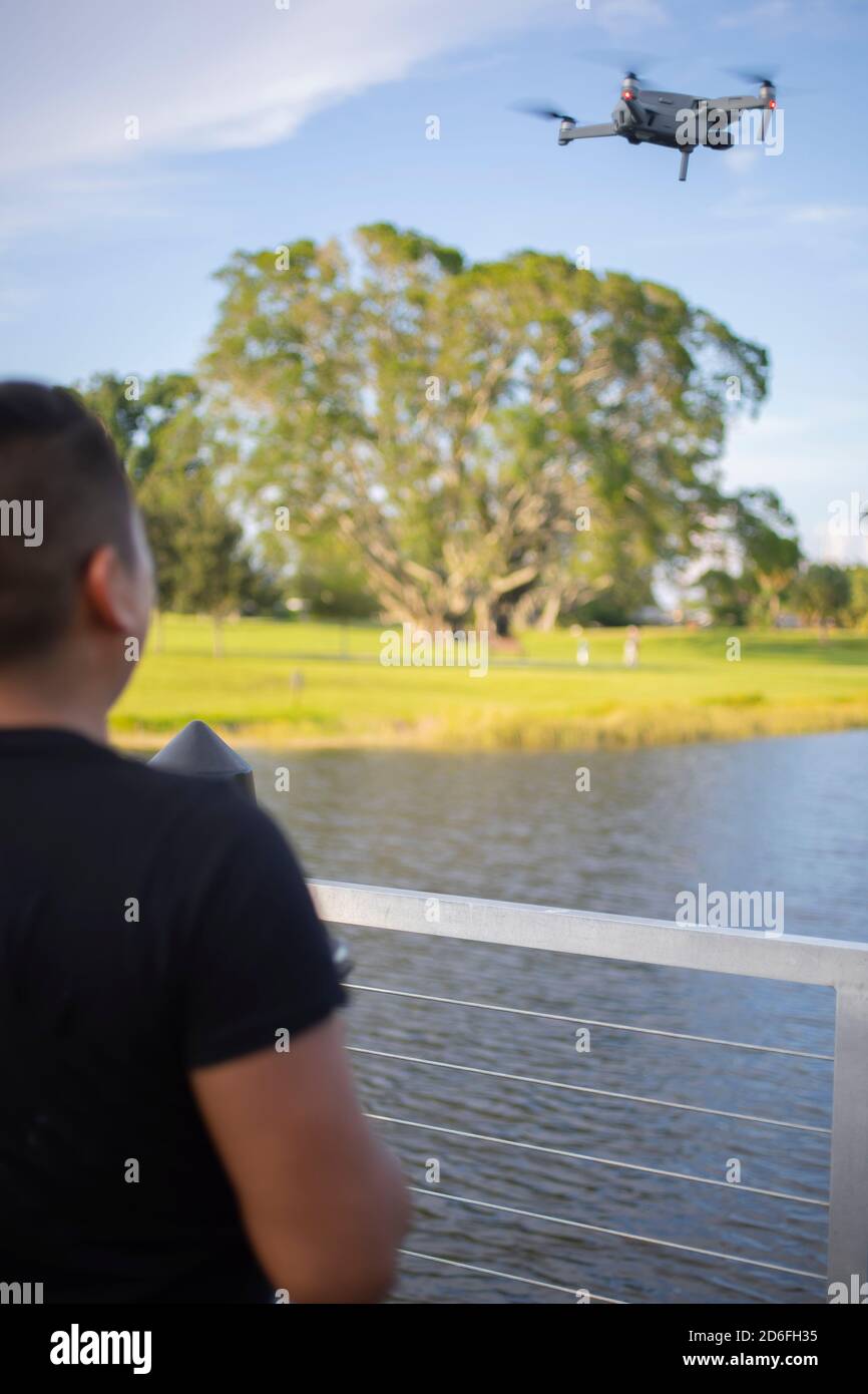 young man flying a drone in the park in a sunset Stock Photo