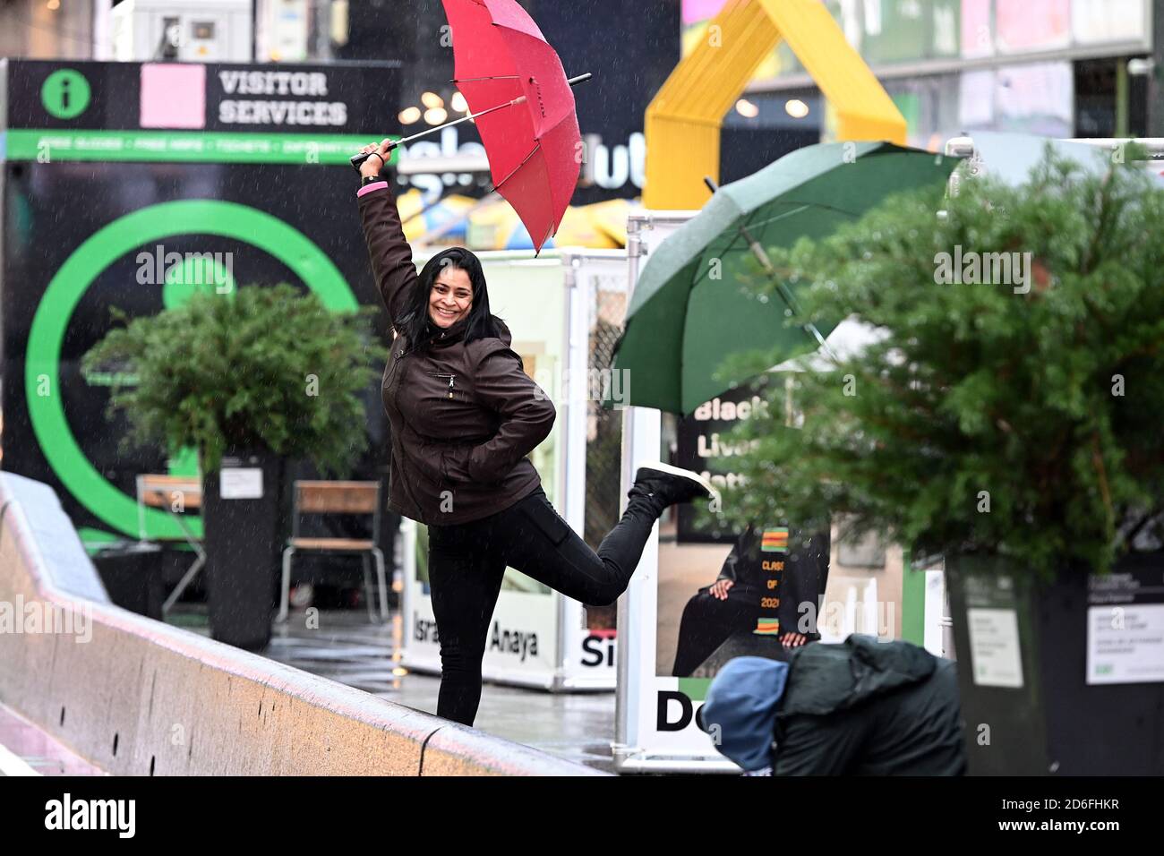 New York City, USA. 16th Oct, 2020. A woman strikes a pose for a friend with a camera in Times Square, New York, NY, October 16, 2020. With the resurgence of COVID-19 spreading across the United States, tourist hot spots like Times Square and it's businesses continue to feel the economic impact of the Coronavirus pandemic. (Anthony Behar/Sipa USA) Credit: Sipa USA/Alamy Live News Stock Photo