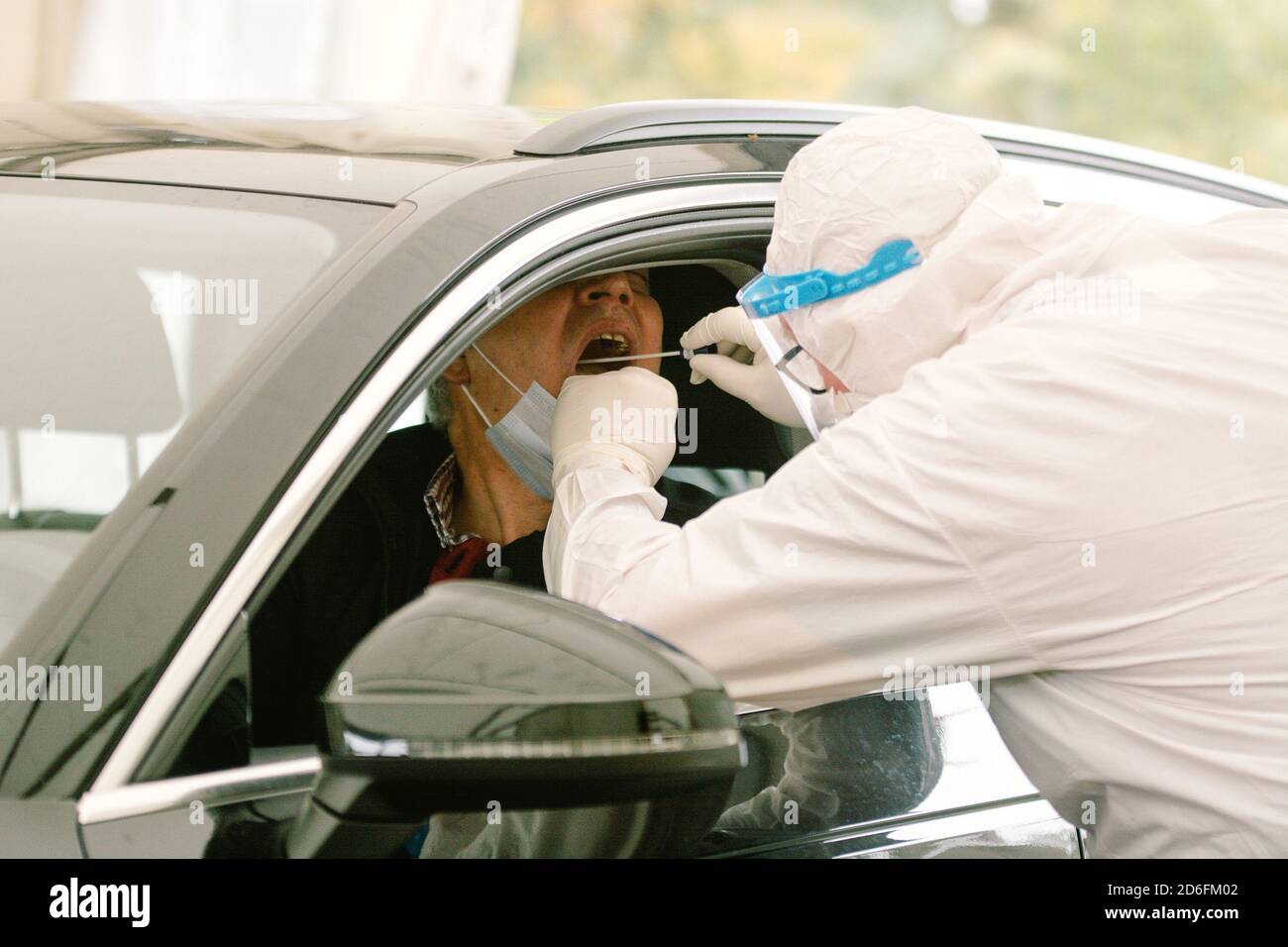 Dusseldorf, Germany. 16th Oct, 2020. A healthcare worker takes a sample from a driver at a drive-in test station in Dusseldorf, Germany, Oct. 16, 2020. New COVID-19 infections in Germany kept climbing and reached a new record with 7,334 cases within one day, bringing the total number to 348,557, the national disease control agency Robert Koch Institute (RKI) announced on Friday. Credit: Tang Ying/Xinhua/Alamy Live News Stock Photo