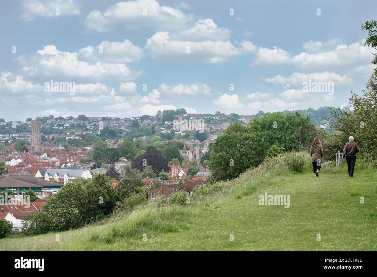 Walking the countryside overlooking Glastonbury town, England. A beautiful summer day, blue sky, white clouds. Stock Photo