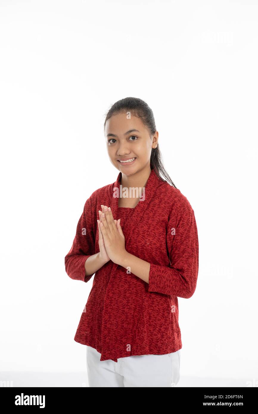 asian young girl smiling and give greetings isolated in white background Stock Photo