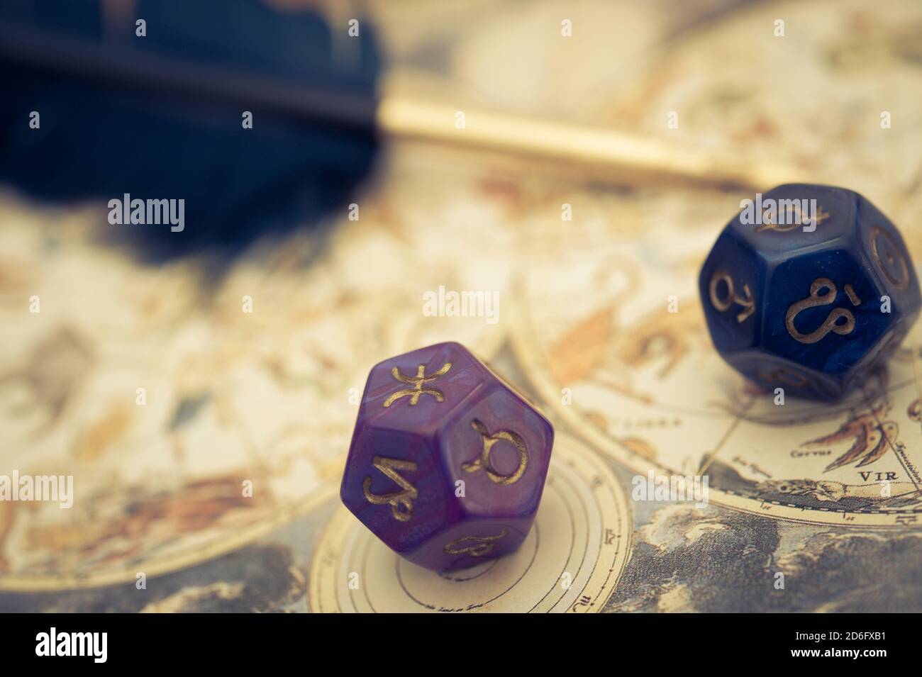 antique astrology chart with zodiac signs and dice with a quill pen