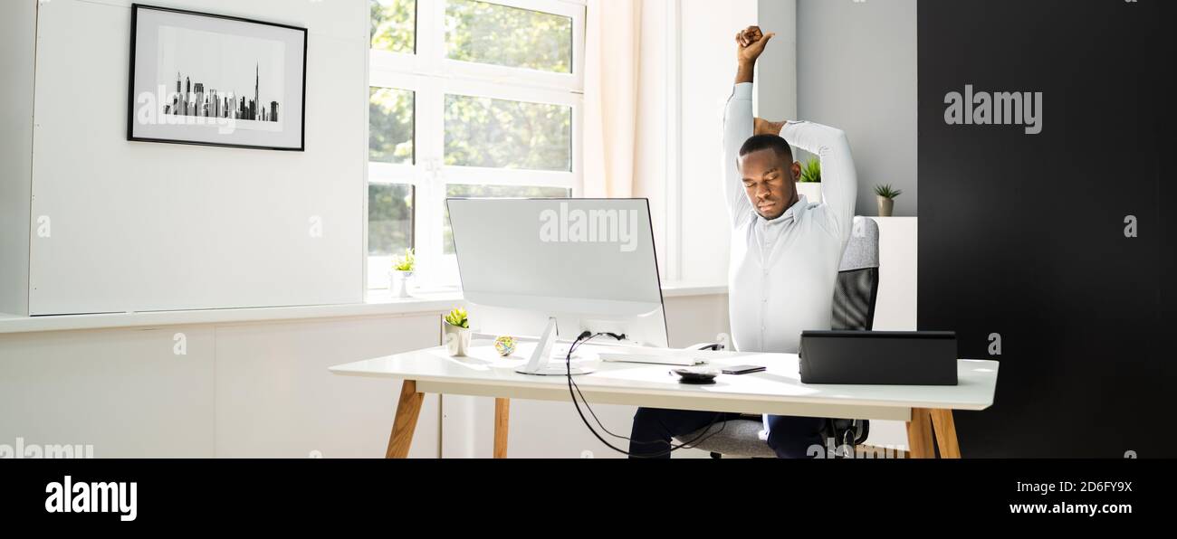 Office Stretch Exercise At Work. African American Man Stock Photo