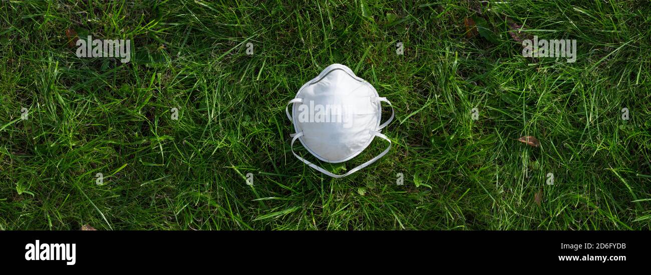Top view close-up face medical mask from corona virus on field grass background , germs and viruses infection respiratory system. Protects Against Vir Stock Photo