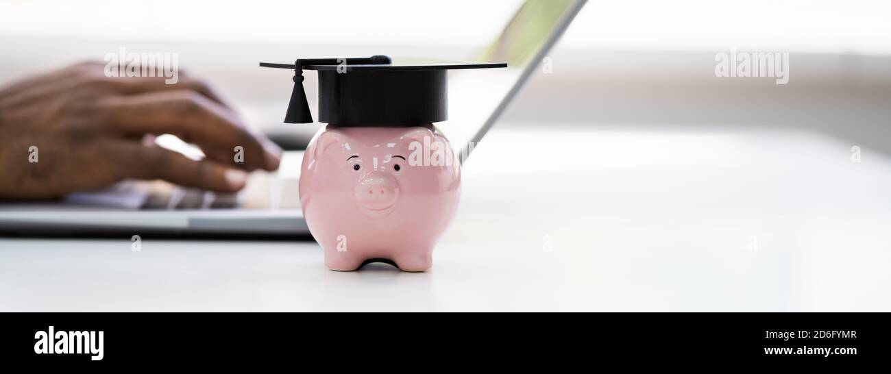 University Graduation Hat On Piggy Bank Near Laptop Computer Stock ...