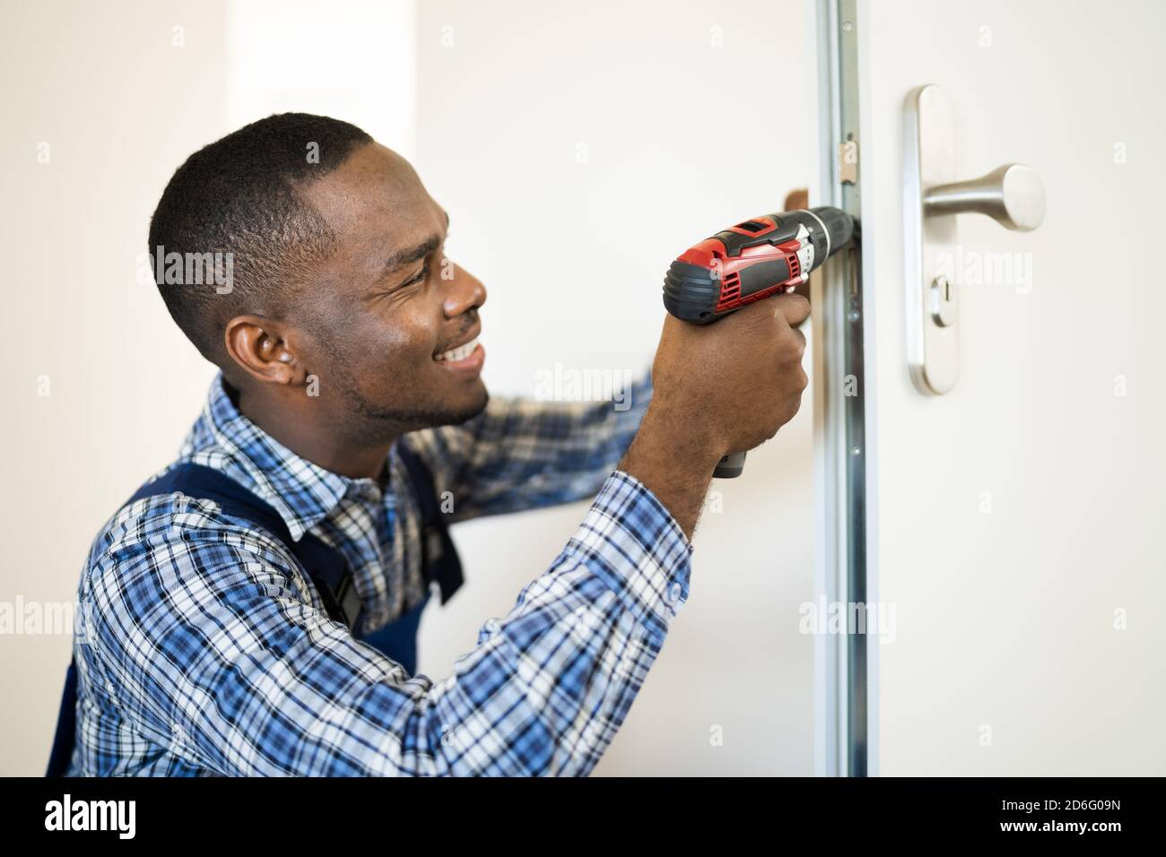 African Locksmith Man Changing And Fixing Door Lock Stock Photo