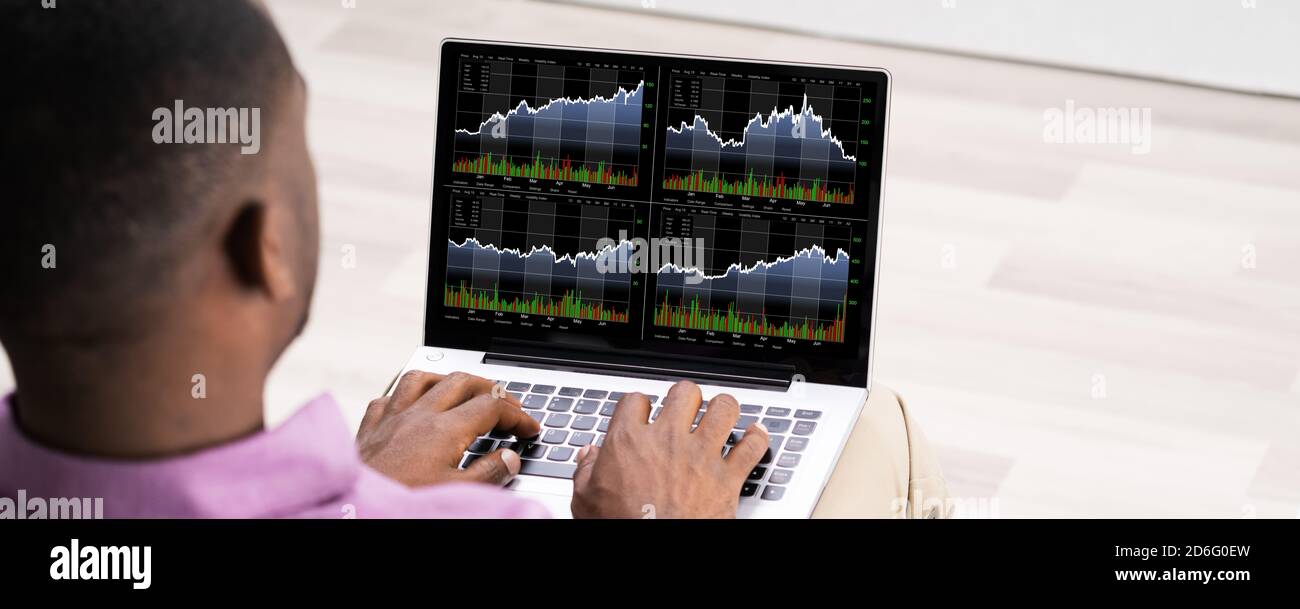 Young African Man Trading Online On Laptop Computer Stock Photo