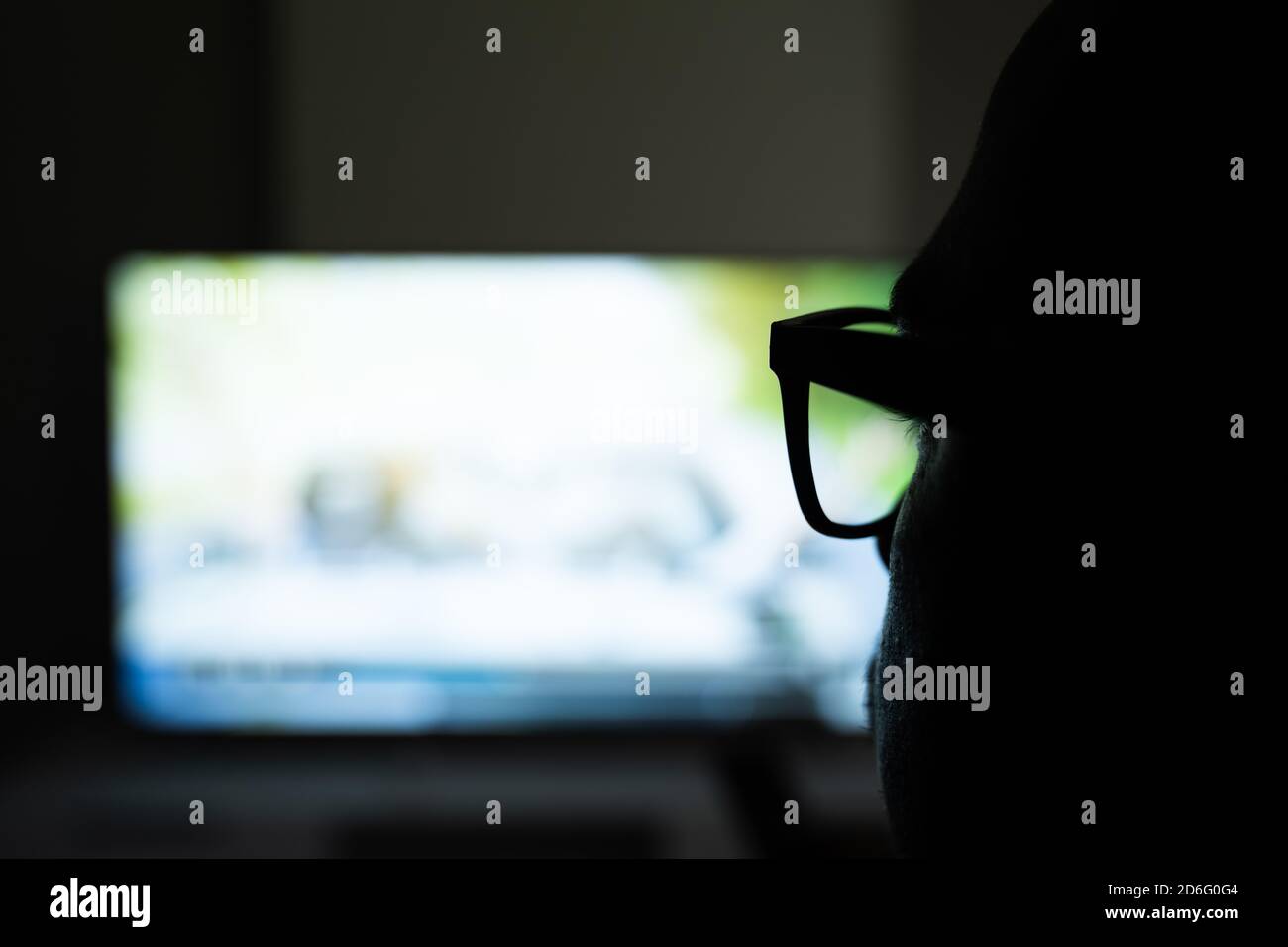 Man Using Magnifying Glasses for Watching TV Stock Photo