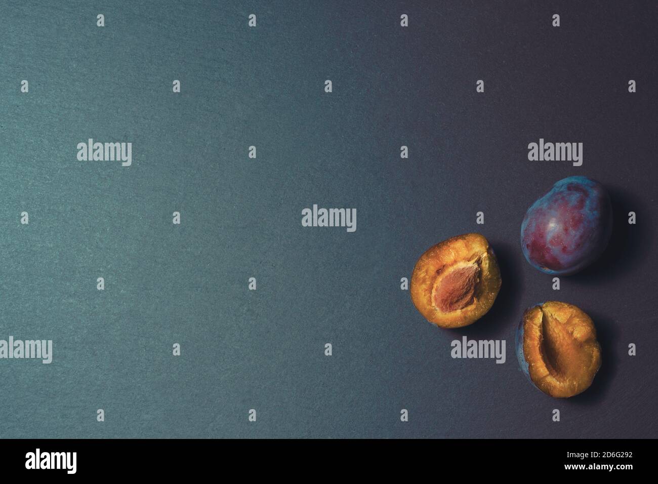 three ripe plums on a kitchen stone table isolated background pattern Stock Photo