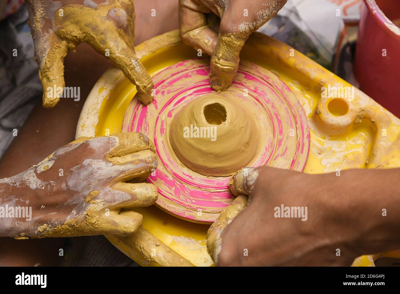 Child learning to make pottery on potters wheel. creating pots by