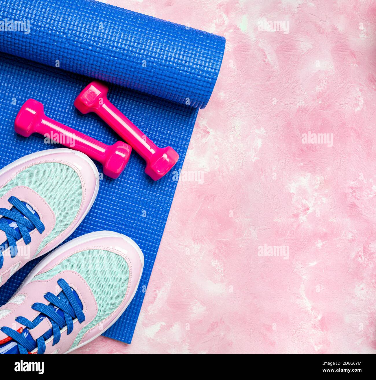 Blue yoga mat, sport shoes, dumbbells on pink background. Concept healthy lifestyle, sport life, sport and diet. Sport equipment. Copy space, top view Stock Photo