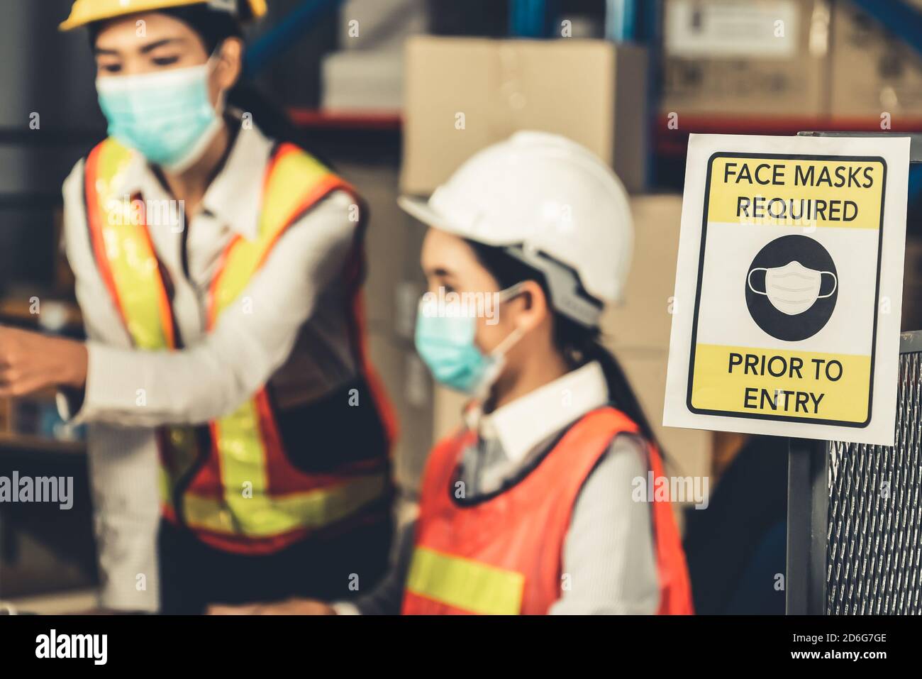 Caution sign in factory warning to industry labor worker to prevent Covid-19 Coronavirus spreading during job business reopening period after epidemic Stock Photo