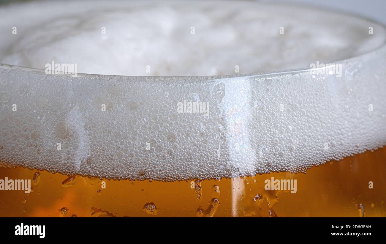 Top of beer glass in closeup displaying all the tiny bubbles and bright