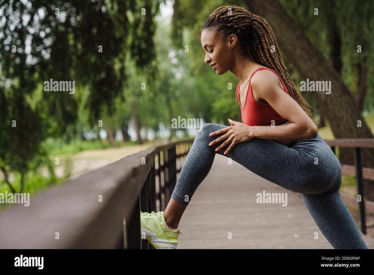 Confident smiling fit young african sports woman doing stretching ...